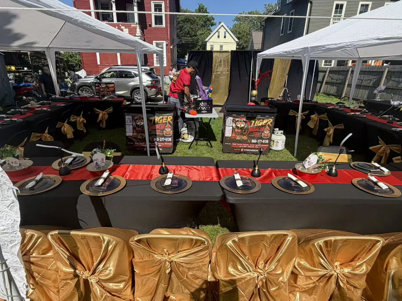 Black and gold hibachi catering table setup under tents before a Connecticut backyard party