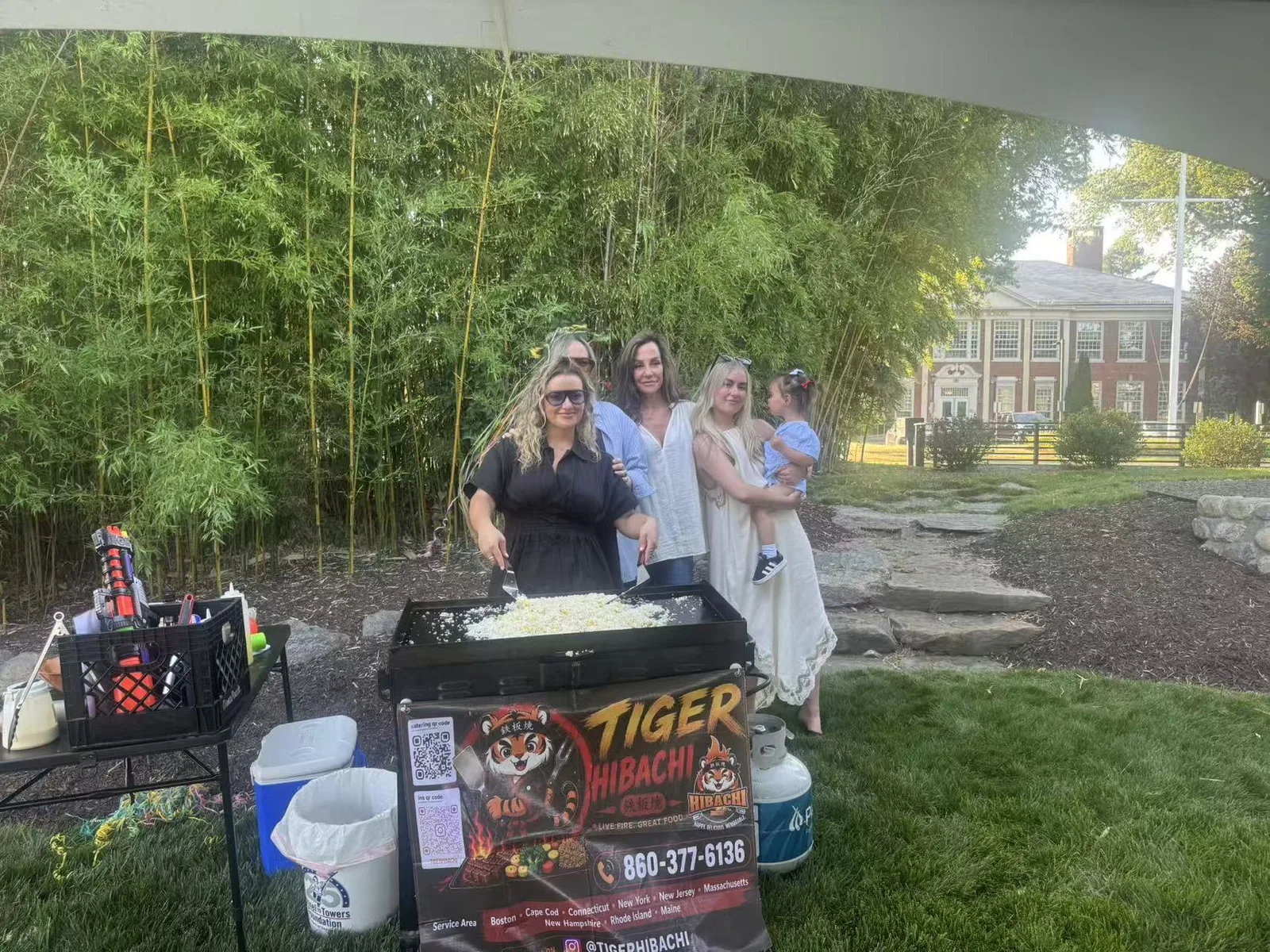 Guests cooking on the hibachi griddle with the chef at a Connecticut garden party
